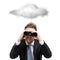 Business man with binocular stands under cloud