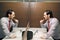 Business Man Brushing Teeth After Lunch Break In Office Bathroom