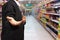 Business man hand holding in supermarket blurry