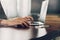 Business man hand texting laptop on wooden table