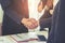 Business man with handshake with partner and woman cheering