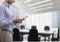 Business man holding a tablet against office background