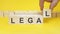 business man holds wooden blocks with the word Legal. the concept of achieving business goals. execution of a business