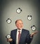 Business man juggling multiple alarm clocks