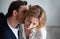 Business man kissing neck of young blonde woman closed eyes. Passion kiss. Enjoyment or workplace romance concept