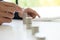 Business man putting coin to rising pile of money and calculator