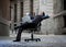 Business Man sitting on Office Chair on Street with Computer