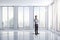 Business man standing in a bright clean room with big windows