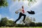 Business man in suit jumping over urban park. Portrait of successful businessman. Fast business concept.