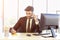 A business man in a suit that is neatly dressed sitting on the phone with a bright smile in the office