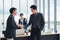 Business man in a suit shakes hands to agree a business partnership agreement. Business etiquette concept of congratulation,