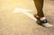 Business man in suit standing on concrete floor with white arrow. Feet and moving forward direction sign on tarmac road. Hope and