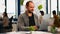 Business man using laptop typing sitting at table in creative cozy office