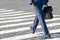 Business man walks on a pedestrian crossing. Goal and success