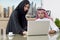 Business Meeting in office , arabian businessman & arabian Secretary wearing hijab working on laptop