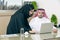 Business Meeting in office , arabian businessman & arabian Secretary wearing hijab working on laptop