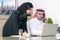 Business Meeting in office , arabian businessman & arabian Secretary wearing hijab working on laptop