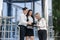 Business meeting outside building. Three young ladies in business suits discussing information on tablet