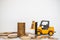 Business, Money and Financial Concept. Closeup  mini forklift truck mini car toy model contain coins to stack of gold coins on