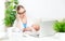 Business mother works at home via Internet with newborn baby