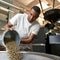 Business owner pouring out coffee beans in grinder