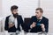 Business partners, businessmen at meeting in office. Manager with beard and colleague with jar of cash and card