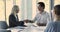 Business partners finish formal meeting in boardroom with hand shake