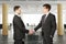 Business partners shake their hands in modern open space office