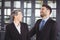 Business people laughing while standing in office