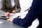 Business people and lawyer discussing contract papers sitting at the table, hands close-up. Teamwork or group operations