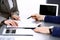 Business people and lawyer discussing contract papers sitting at the table, hands close-up. Teamwork or group operations