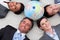 Business people lying on the floor around a globe