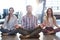 Business people performing yoga on floor