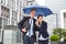 Business people in the rain under umbrella in the city