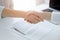 Business people shaking hands above contract papers just signed on the white table, closeup. Lawyers at meeting