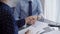 Business people shaking hands above the grey glass table, close up. Entrepreneurs or accountants at work. Agreement and