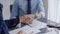 Business people shaking hands above the grey glass table, close up. Entrepreneurs or accountants at work. Agreement and