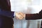 Business people shaking hands, close-up. Group of unknown businessmen standing in a sunny modern office. Teamwork