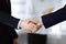 Business people shaking hands at meeting or negotiation, close-up. Group of unknown businessmen and a woman standing in