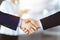 Business people shaking hands at meeting or negotiation, close-up. Group of unknown businessmen and a woman standing in