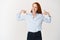 Business people. Skillful young redhead woman pointing at herself and smiling, being a professional, standing over white