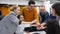 Business people stack hands in pile over meeting table, cheer together in corporate teambuilding event in office