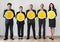 Business people standing and holding currency icons