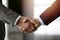 Business people standing and shaking hands in sunny office, close-up. Handshake and marketing