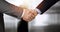 Business people standing and shaking hands in sunny office, close-up. Handshake and marketing