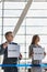 Business people waiting while holding white placard with their boss name in arrival area at airport