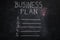 Business plan list and lightbulb on black chalkboard