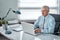 Business portrait of an elderly man. An aged man working on a laptop. Work on removal, freelance.