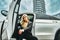 Business portrait of girl in an expensive car on the background of the city
