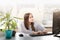 Business at a remote work. A young girl sits at a table typing on a computer